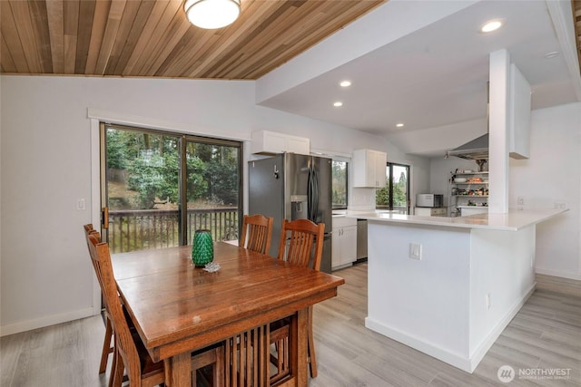 dining space with recessed lighting, light wood-style flooring, baseboards, and vaulted ceiling