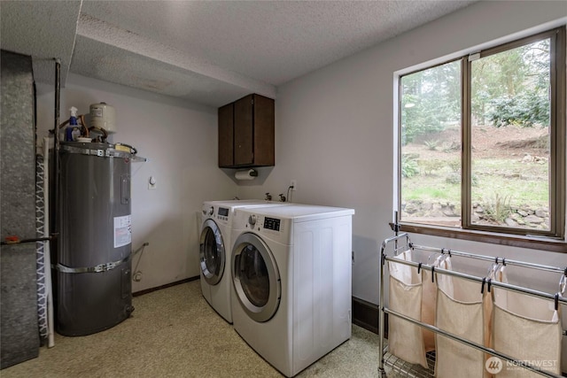 laundry room with washing machine and clothes dryer, plenty of natural light, a textured ceiling, and water heater