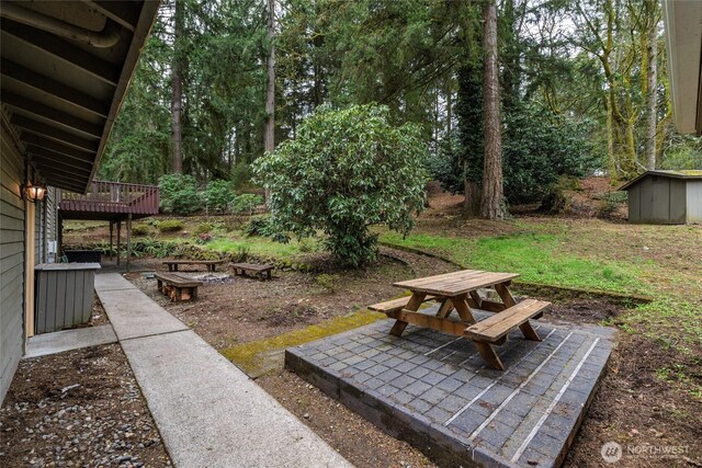 view of yard featuring a patio, an outbuilding, outdoor dining space, and a shed