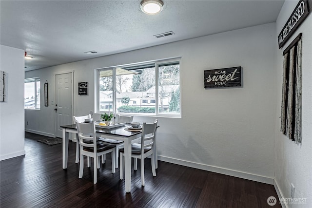 dining room with visible vents, a textured ceiling, baseboards, and dark wood-type flooring