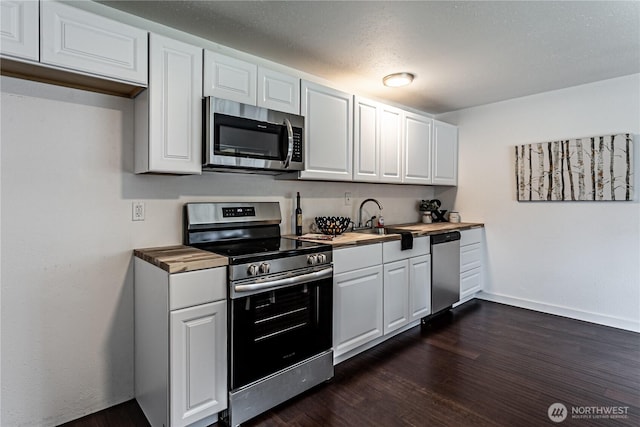 kitchen with stainless steel appliances, dark wood-style flooring, white cabinets, and a sink