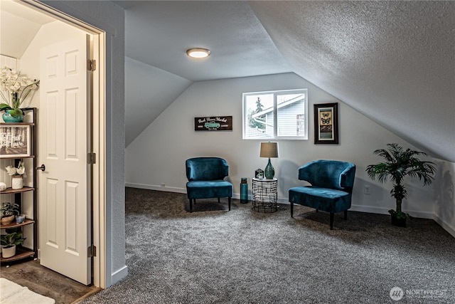 sitting room with a textured ceiling, baseboards, carpet flooring, and lofted ceiling