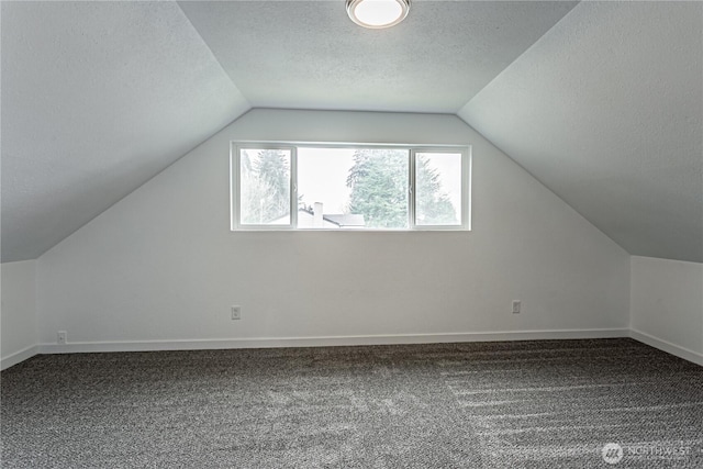 bonus room with a textured ceiling, vaulted ceiling, carpet, and baseboards