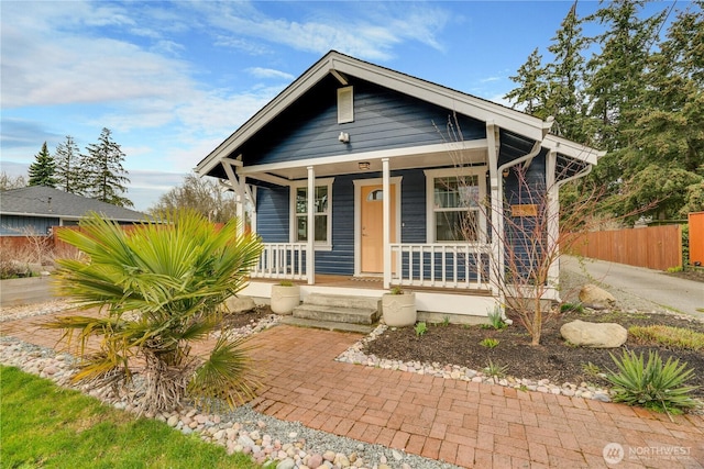 bungalow with a porch and fence