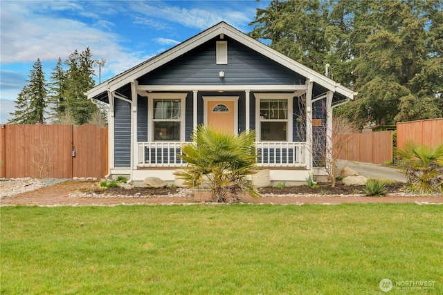 bungalow-style home featuring a porch, a front lawn, and fence