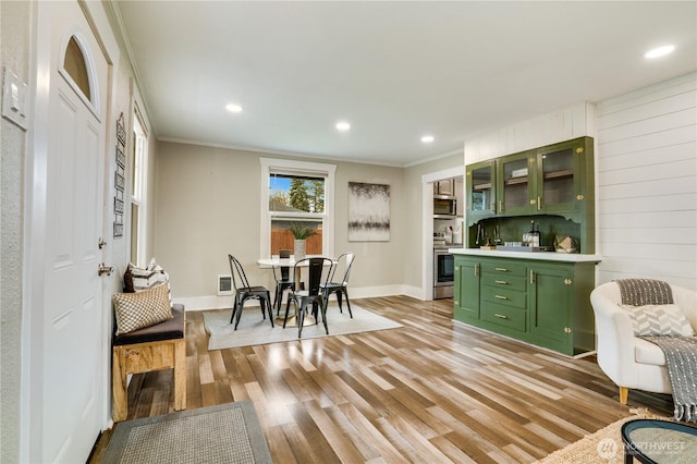 interior space with stainless steel appliances, light wood-style floors, crown molding, light countertops, and green cabinetry