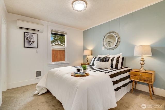 carpeted bedroom featuring visible vents, a textured ceiling, a wall unit AC, crown molding, and baseboards