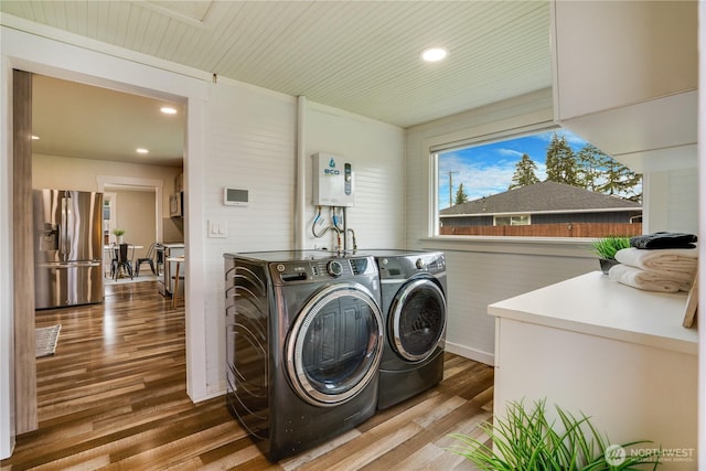 laundry room featuring laundry area, wood finished floors, washing machine and dryer, and recessed lighting