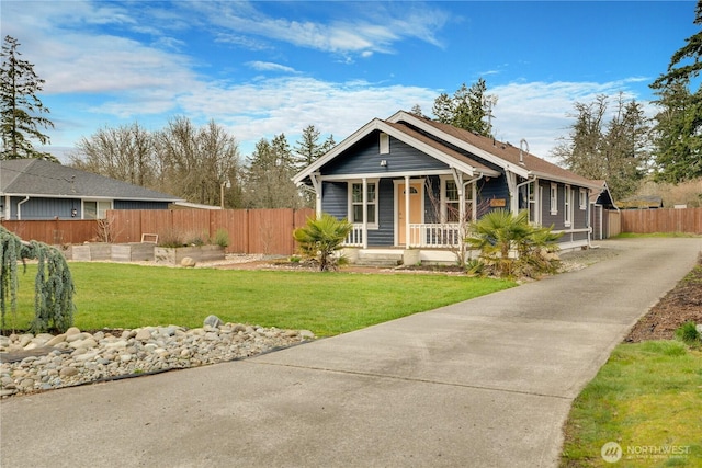 view of front facade featuring a porch, a front lawn, and fence