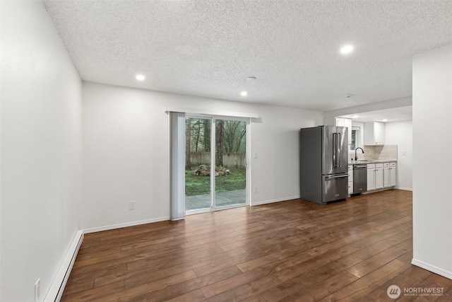 unfurnished living room with a baseboard radiator, recessed lighting, dark wood-type flooring, a sink, and baseboards