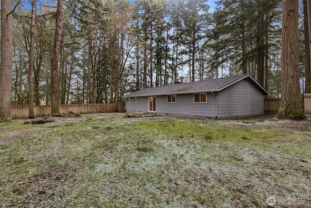 rear view of house with crawl space and fence