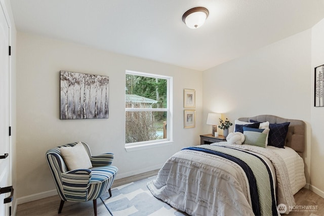 bedroom with baseboards and wood finished floors
