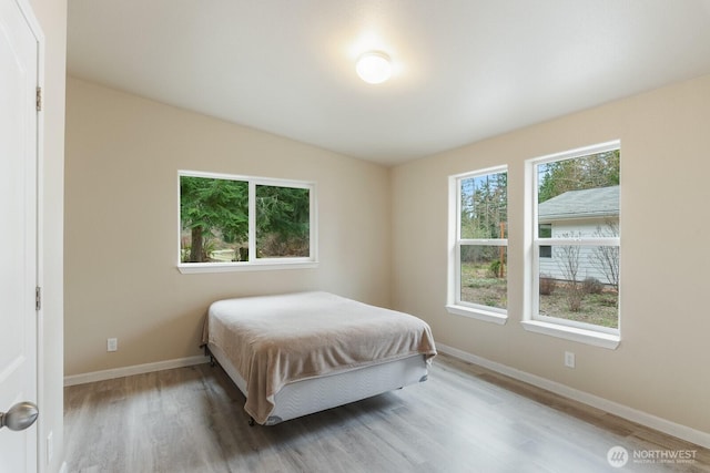 bedroom with baseboards and wood finished floors