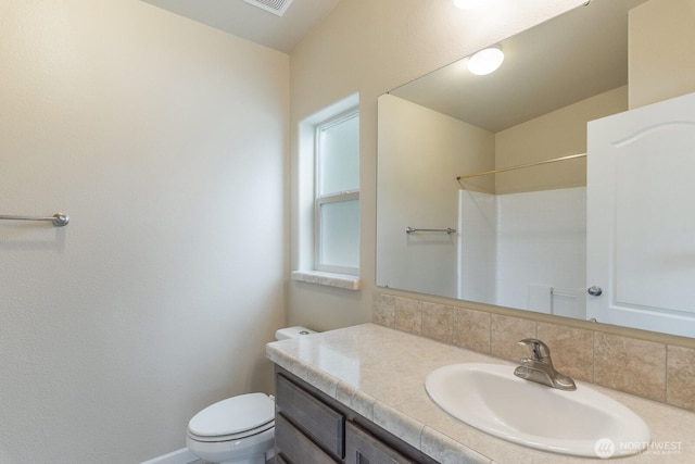 full bathroom featuring toilet, vanity, and baseboards