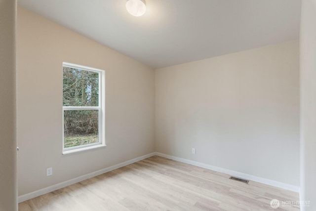 unfurnished room featuring light wood-style floors, baseboards, visible vents, and plenty of natural light