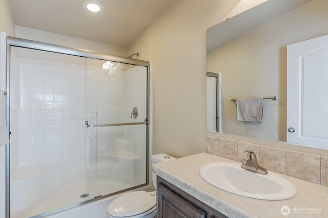 full bathroom with toilet, vanity, backsplash, and a shower with door