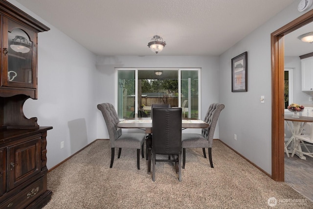 carpeted dining space featuring baseboards