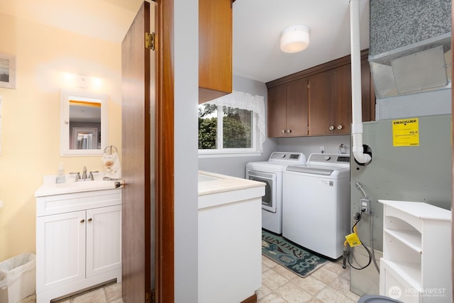 laundry area featuring cabinet space, washer and dryer, light floors, and a sink