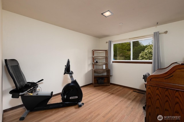 exercise room with light wood-type flooring and baseboards