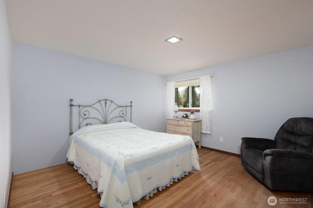 bedroom with baseboards and light wood finished floors