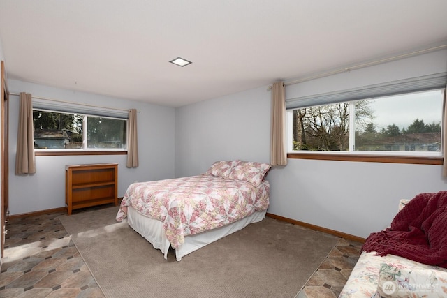 bedroom featuring stone finish flooring and baseboards