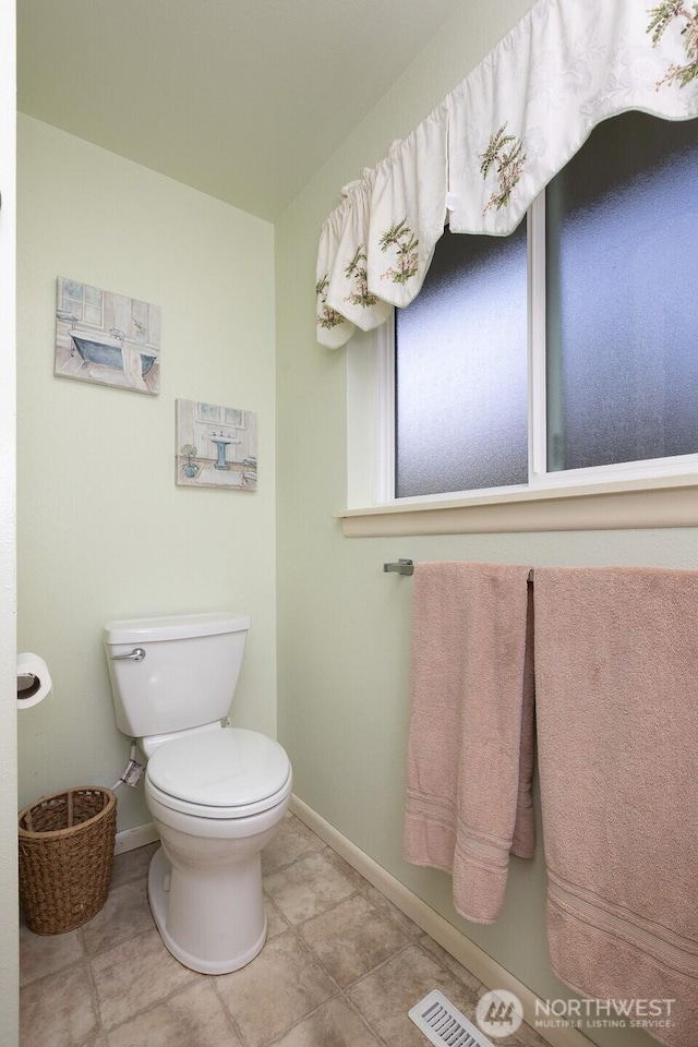 bathroom with toilet, baseboards, and visible vents