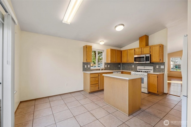 kitchen with white appliances, lofted ceiling, light tile patterned flooring, decorative backsplash, and light countertops