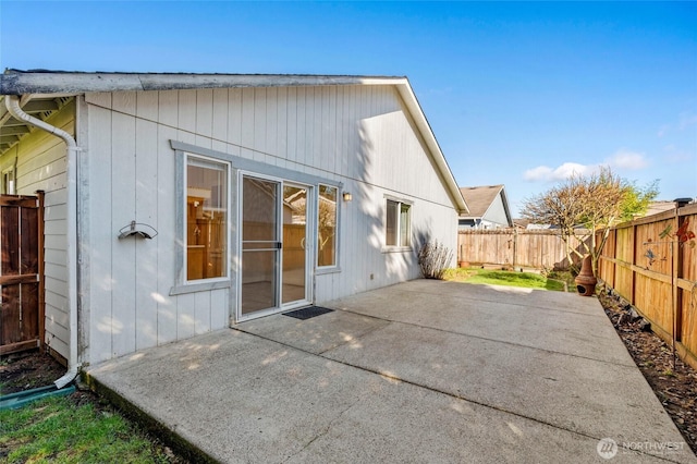 rear view of property featuring a patio and a fenced backyard