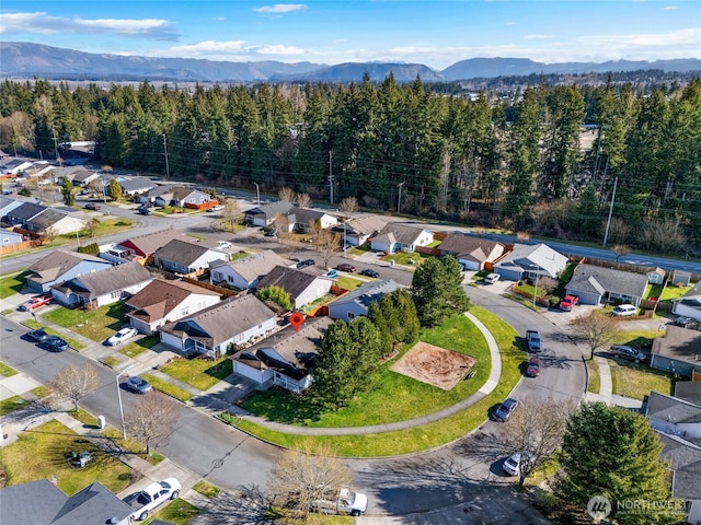 aerial view with a mountain view, a residential view, and a view of trees