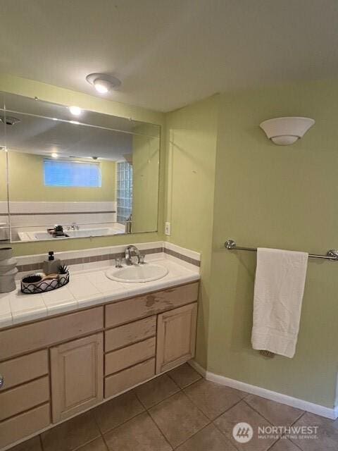 bathroom with baseboards, vanity, and tile patterned floors