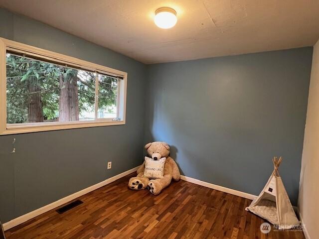 interior space featuring visible vents, baseboards, and wood finished floors