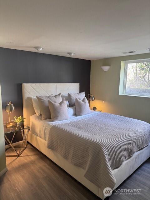 bedroom featuring visible vents and wood finished floors