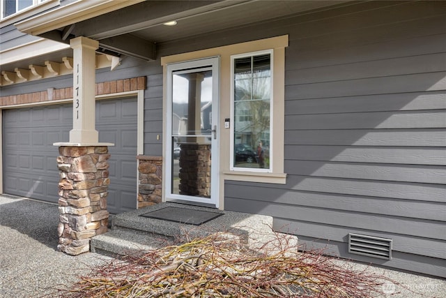 property entrance featuring a garage and visible vents