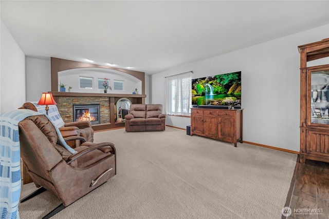 living room with a fireplace and baseboards