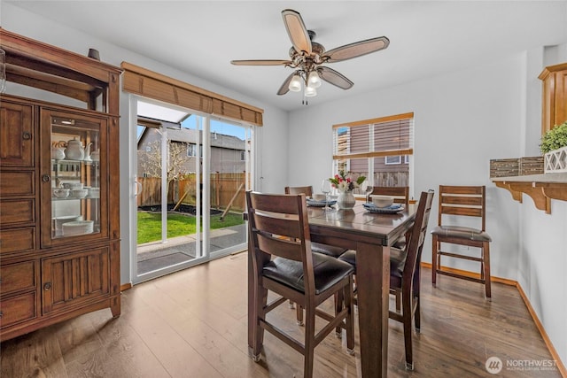 dining room with baseboards, a ceiling fan, and wood finished floors