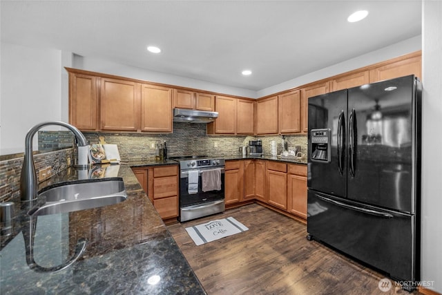 kitchen with under cabinet range hood, stainless steel range with electric stovetop, black refrigerator with ice dispenser, dark wood-style floors, and a sink