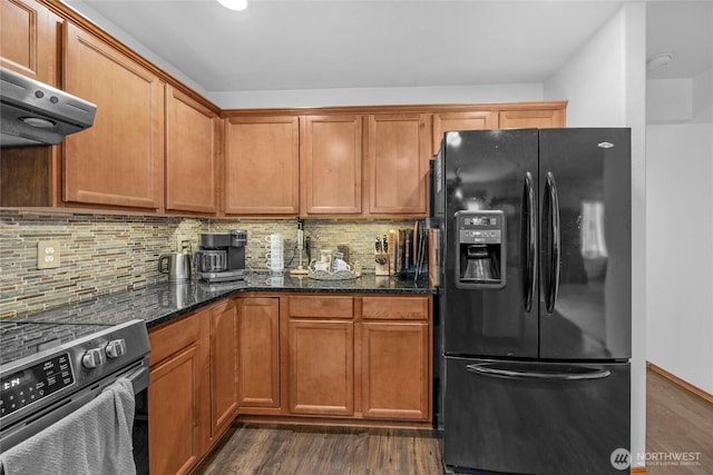 kitchen featuring dark wood-style floors, decorative backsplash, black fridge, and electric stove