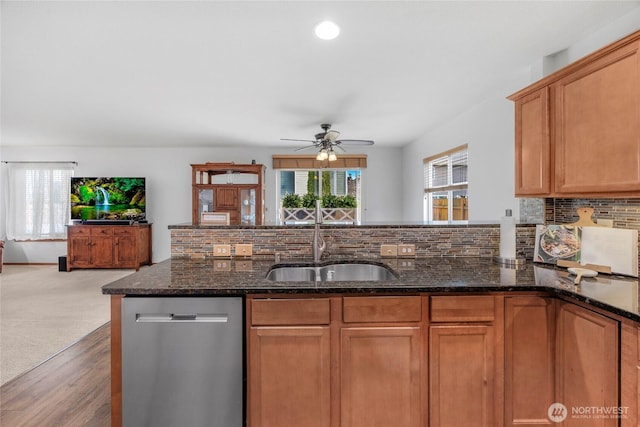 kitchen featuring backsplash, a healthy amount of sunlight, dishwasher, and a sink