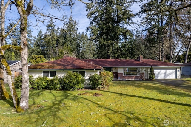 single story home featuring a garage, a chimney, and a front yard