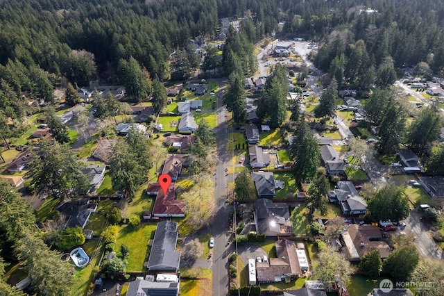 birds eye view of property featuring a wooded view and a residential view