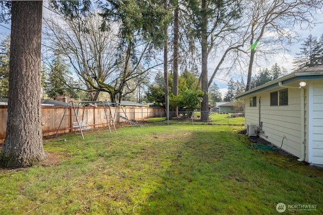 view of yard with central AC unit and a fenced backyard