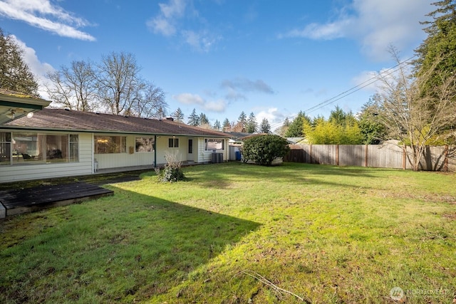 view of yard featuring central AC and fence