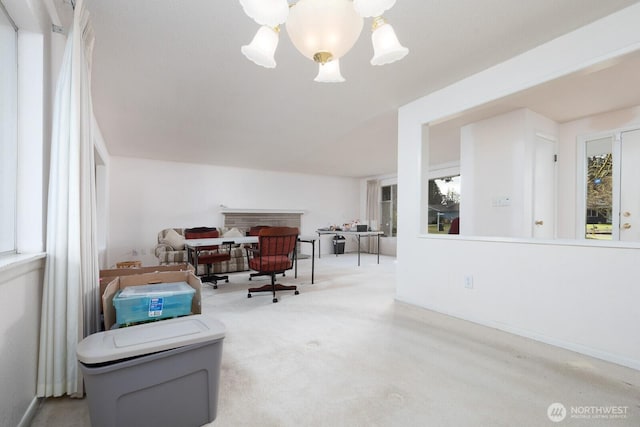 living area with a notable chandelier, carpet, and baseboards