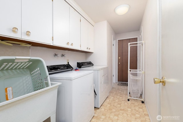 laundry room featuring washing machine and dryer, cabinet space, and light floors