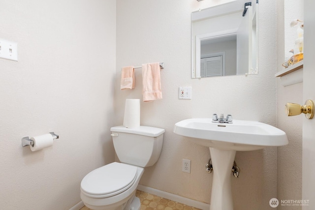 bathroom featuring toilet and baseboards