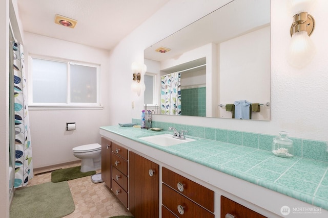 bathroom with vanity, curtained shower, and toilet