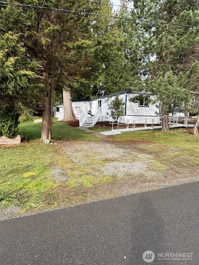 manufactured / mobile home with covered porch and a front lawn