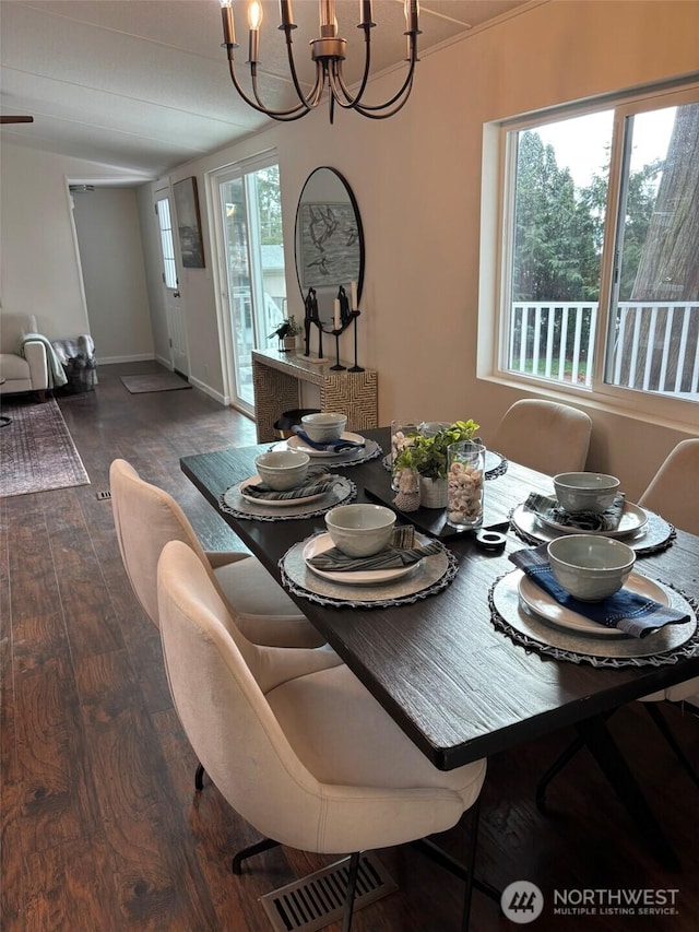 dining space with a notable chandelier, plenty of natural light, wood finished floors, and visible vents