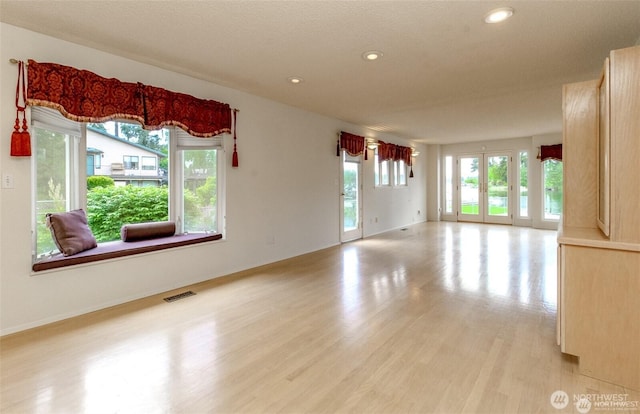 empty room featuring light wood finished floors, baseboards, visible vents, and recessed lighting