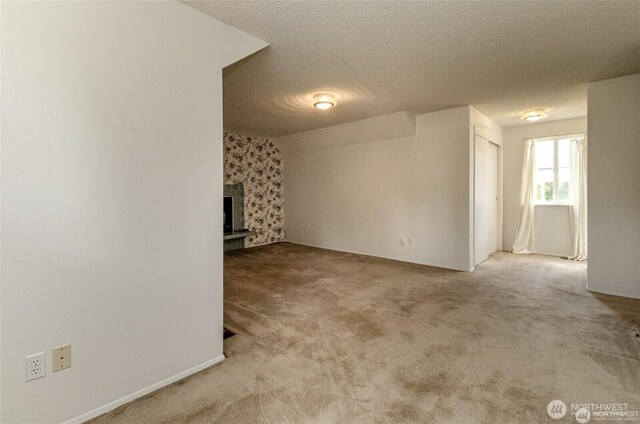 carpeted spare room with a textured ceiling